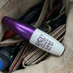 Purple and white bottle of Olay Total Effects 8-in-1 Serum in a brown leather bag.